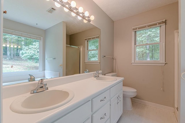 bathroom featuring vanity, a textured ceiling, an enclosed shower, toilet, and tile patterned floors