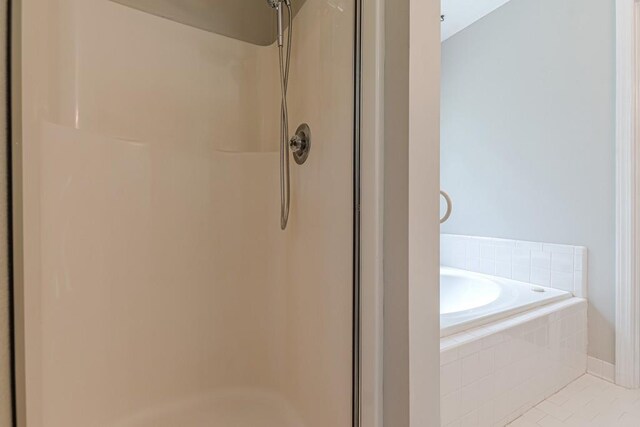 bathroom featuring plus walk in shower and tile patterned floors