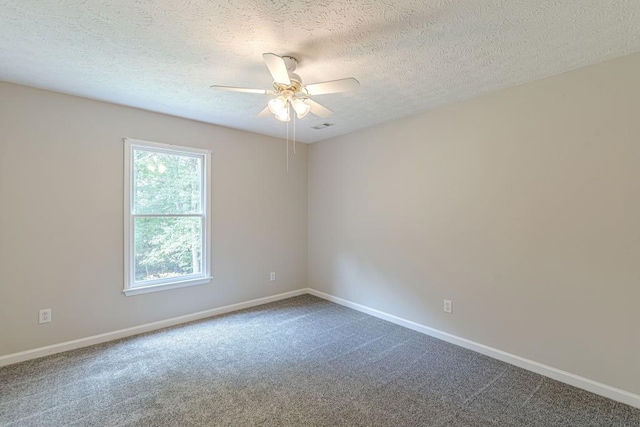 empty room with ceiling fan, a textured ceiling, and carpet