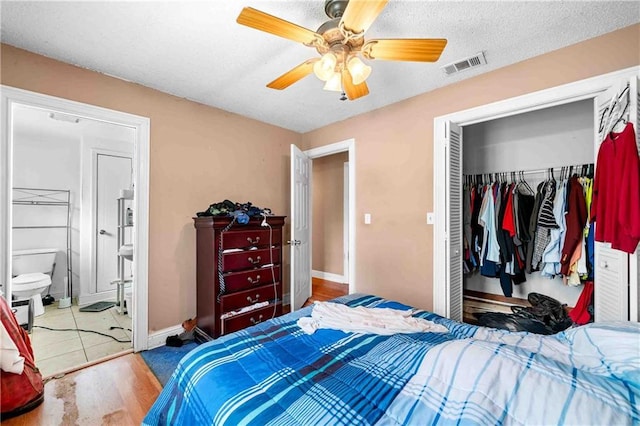 bedroom featuring a closet, a ceiling fan, a textured ceiling, baseboards, and visible vents