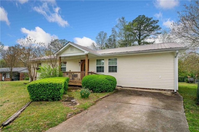 ranch-style home with metal roof, a porch, and a front yard