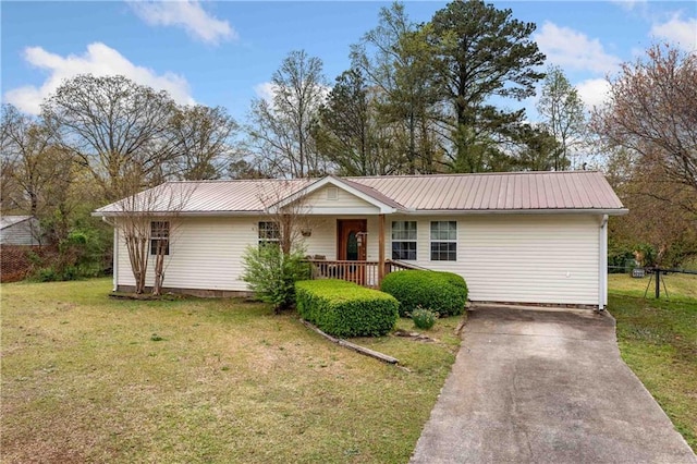 single story home with driveway, metal roof, a porch, and a front yard