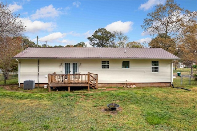 back of property featuring french doors, a fire pit, a deck, and metal roof