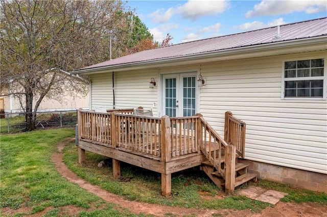 wooden deck with a lawn, fence, and french doors