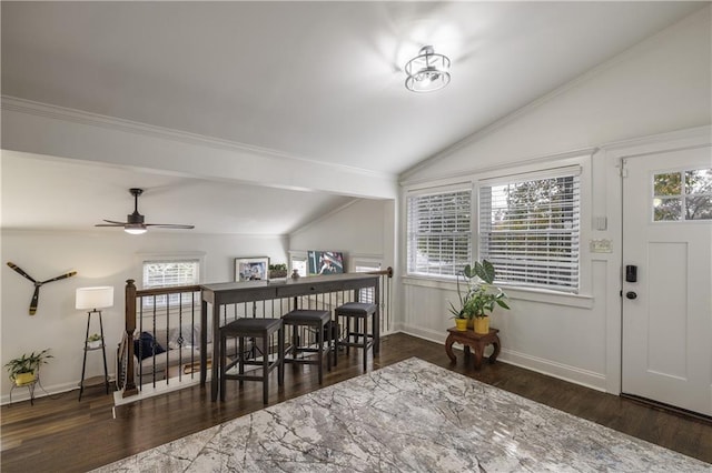 interior space featuring vaulted ceiling, wood finished floors, and baseboards