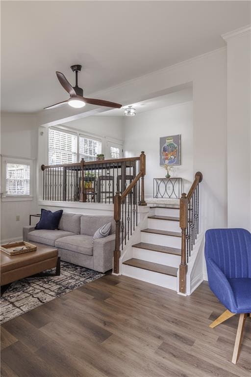 interior space featuring stairs, wood finished floors, a ceiling fan, and crown molding