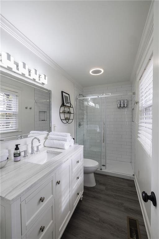 full bathroom with visible vents, ornamental molding, wood finished floors, vanity, and a shower stall