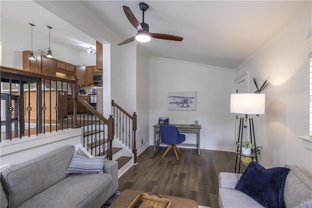 living room with dark wood-style flooring, a ceiling fan, baseboards, stairway, and crown molding