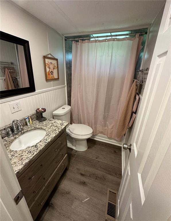 241 Wooten Ct, Canton, GA 30114 - full bath featuring vanity, wood finished floors, wainscoting, and a shower with curtain