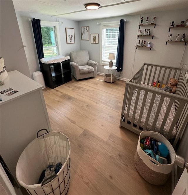 241 Wooten Ct, Canton, GA 30114 - bedroom featuring light wood-style flooring, a crib, and multiple windows