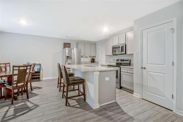 370 Cassidy Trl, Douglasville, GA 30134 - kitchen featuring appliances with stainless steel finishes, a sink, a kitchen breakfast bar, light wood-type flooring, and recessed lighting
