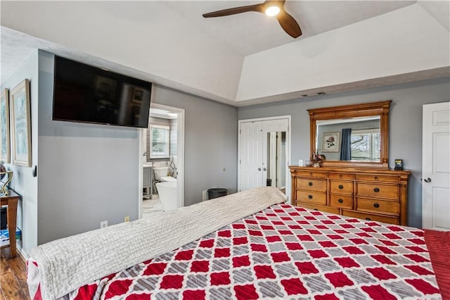 bedroom with connected bathroom, ceiling fan, lofted ceiling, wood finished floors, and a closet