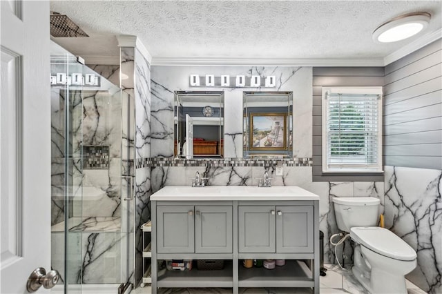 full bathroom featuring a marble finish shower, toilet, crown molding, and a sink