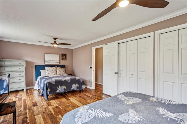 bedroom featuring a ceiling fan, crown molding, wood finished floors, and baseboards