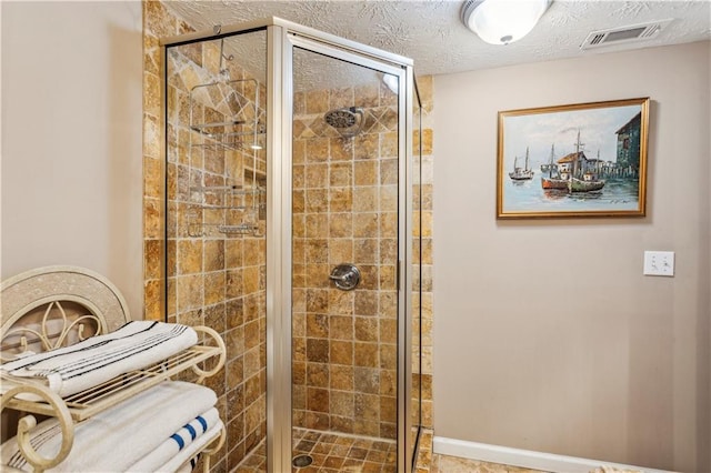 bathroom with a shower stall, visible vents, and a textured ceiling