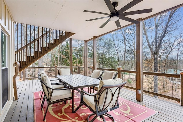 wooden terrace featuring stairway, ceiling fan, and outdoor dining space