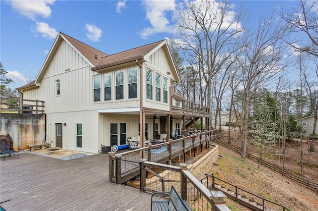 rear view of house with stairway, board and batten siding, and a wooden deck