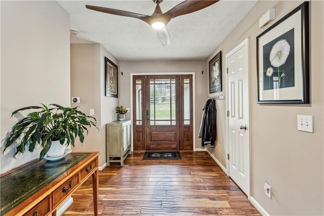 foyer featuring baseboards, a textured ceiling, a ceiling fan, and hardwood / wood-style flooring