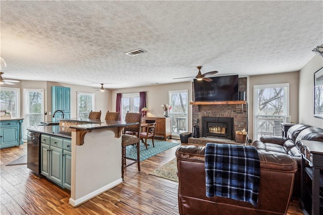 kitchen featuring a breakfast bar, wood finished floors, open floor plan, and ceiling fan