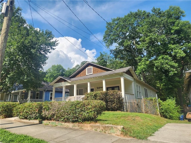 bungalow with covered porch and a front yard