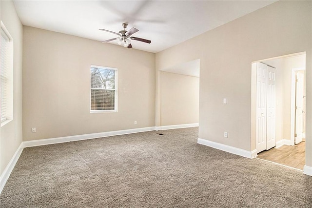 carpeted spare room featuring ceiling fan