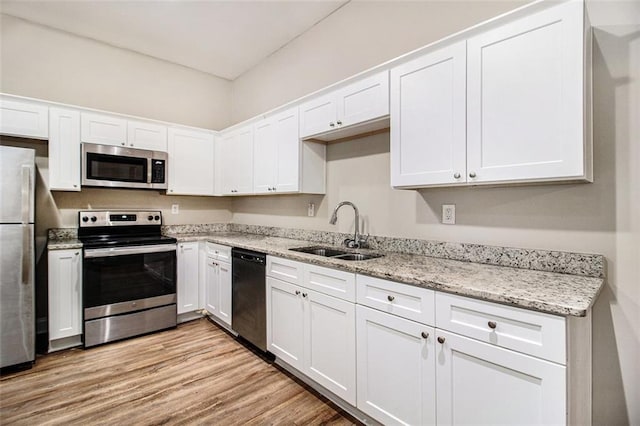 kitchen with white cabinetry, sink, stainless steel appliances, and light wood-type flooring