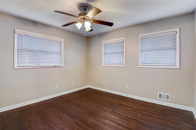 empty room with dark hardwood / wood-style flooring and ceiling fan