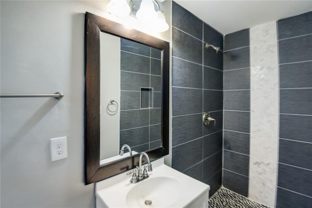 bathroom featuring vanity and tiled shower