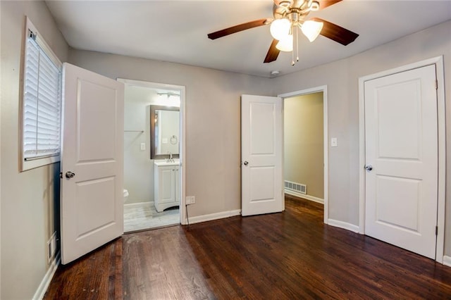 unfurnished bedroom with ceiling fan, dark hardwood / wood-style floors, and connected bathroom