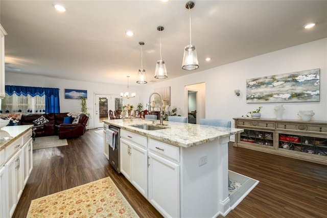 kitchen featuring pendant lighting, a center island with sink, and white cabinetry