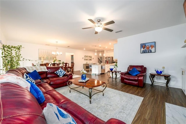 living room featuring wood-type flooring and ceiling fan with notable chandelier