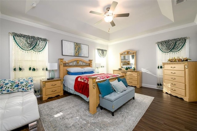 bedroom with a tray ceiling, ceiling fan, and dark hardwood / wood-style floors