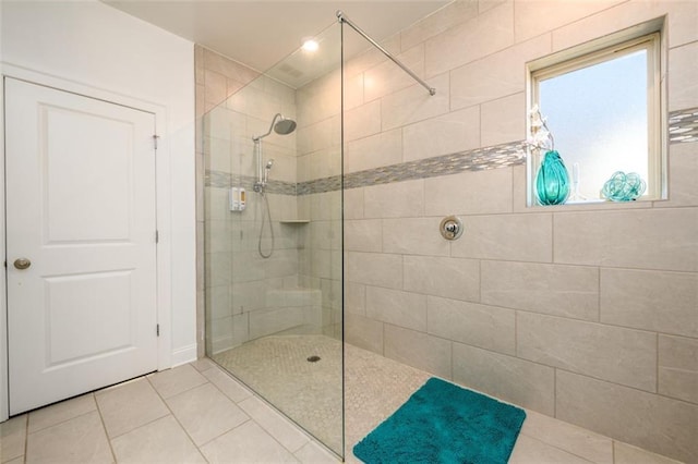 bathroom with tile patterned floors and a tile shower