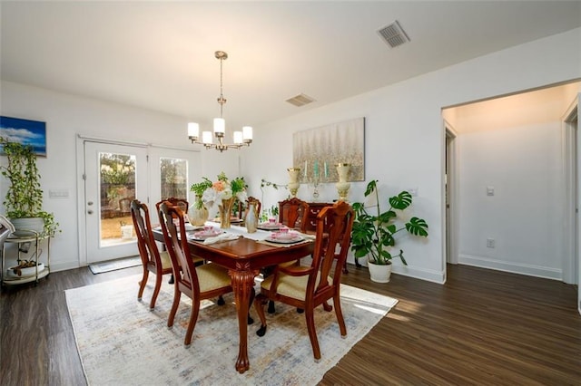 dining room featuring an inviting chandelier and dark wood-type flooring