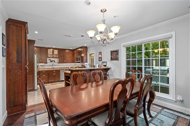 dining room featuring crown molding, dark hardwood / wood-style floors, and a notable chandelier