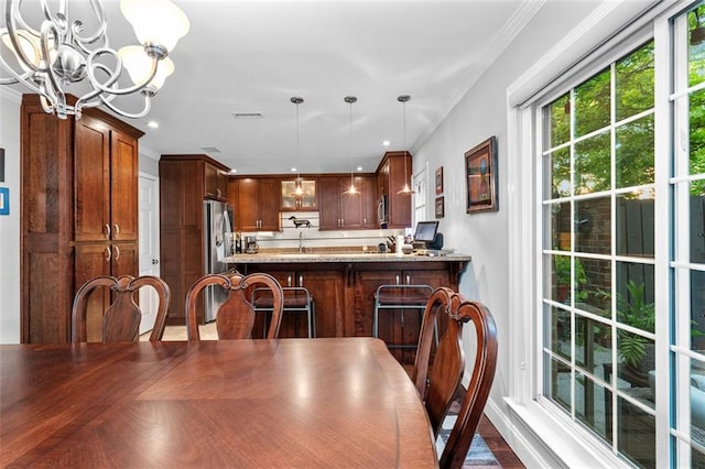 dining room featuring ornamental molding, a chandelier, parquet floors, and sink