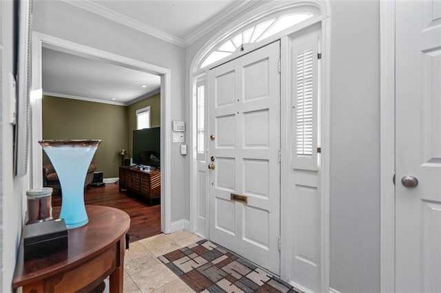 entryway with ornamental molding and light hardwood / wood-style floors