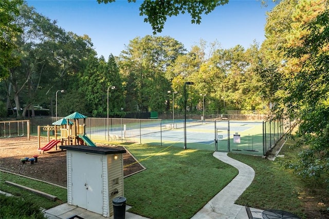 view of tennis court featuring a playground and a yard