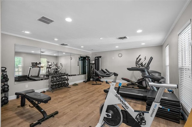 exercise room with ornamental molding and hardwood / wood-style flooring