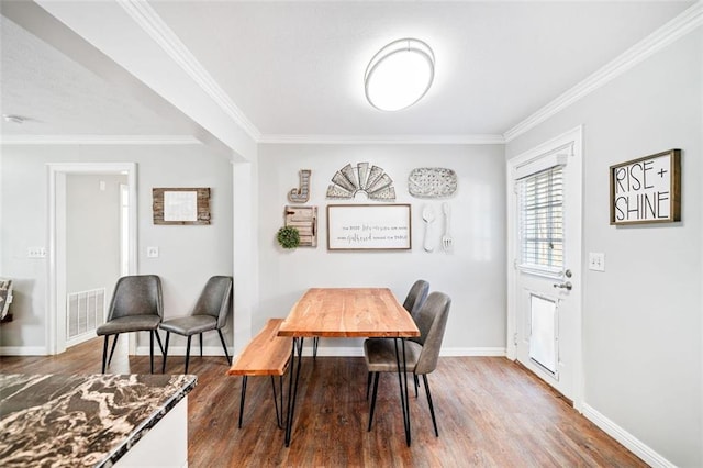 dining space with crown molding and hardwood / wood-style floors