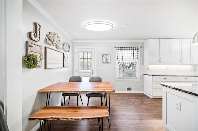 dining space featuring crown molding and dark wood-type flooring