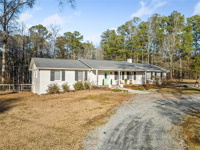 ranch-style house featuring a front lawn and covered porch