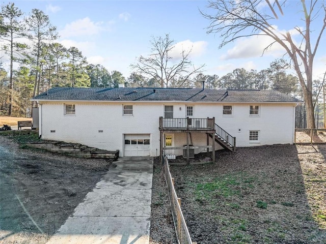 back of property featuring a wooden deck and a garage