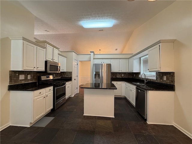 1245 Mulberry Mill Ln, Lawrenceville, GA 30043 - kitchen with appliances with stainless steel finishes, lofted ceiling, a kitchen island, tasteful backsplash, and a textured ceiling