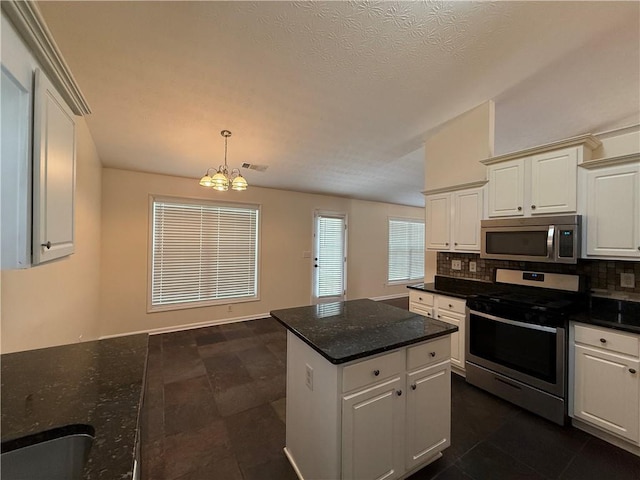 1245 Mulberry Mill Ln, Lawrenceville, GA 30043 - kitchen featuring appliances with stainless steel finishes, a chandelier, decorative backsplash, a center island, and white cabinetry