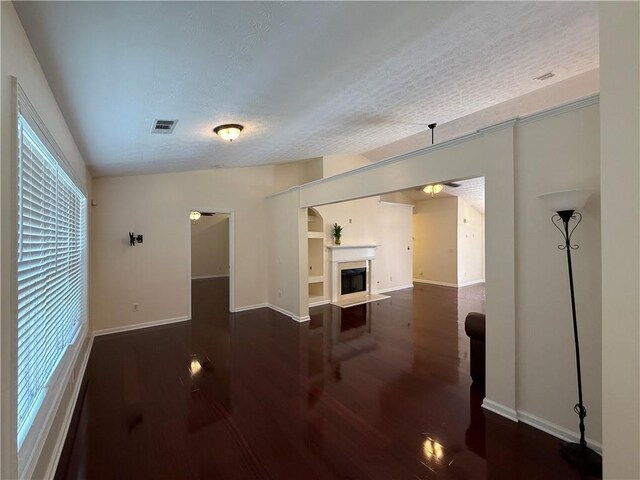 1245 Mulberry Mill Ln, Lawrenceville, GA 30043 - unfurnished living room featuring dark wood-style flooring, a fireplace, and a textured ceiling