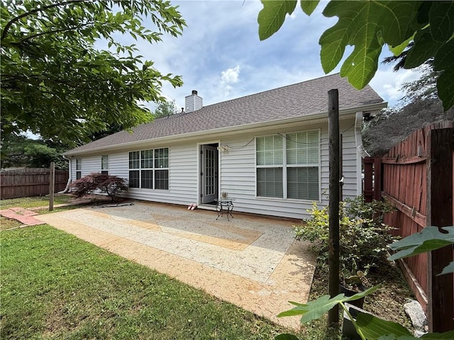 1245 Mulberry Mill Ln, Lawrenceville, GA 30043 - back of property with a patio area, a fenced backyard, a chimney, and roof with shingles