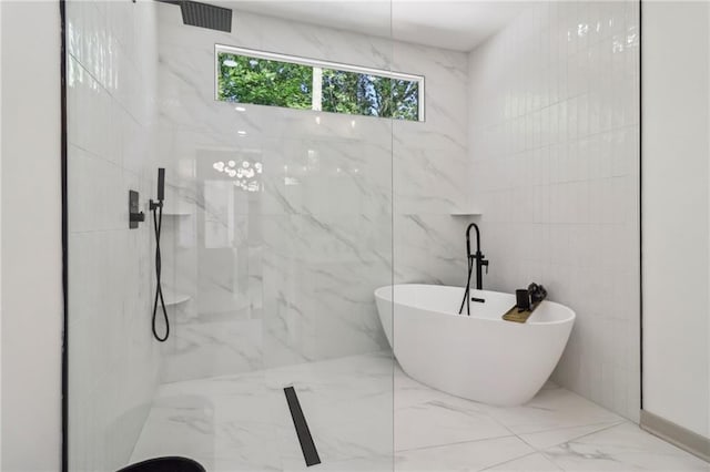 1129 Victory Dr SW, Atlanta, GA 30310 - bathroom with marble tiled floors, a soaking tub, a marble finish shower, tile walls, and a chandelier