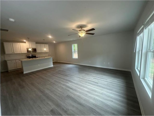 75 Emerald Ln, Covington, GA 30014 - unfurnished living room with baseboards, dark wood-style floors, and ceiling fan