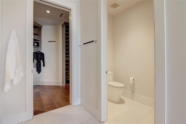 bathroom featuring wood-type flooring and toilet